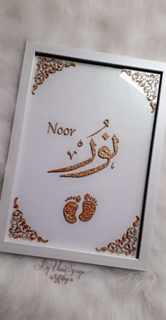 an arabic calligraphy is displayed on a white background with gold trimmings and embellishments