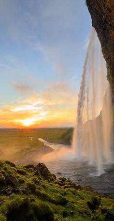 a large waterfall spewing out water into the air at sunset or dawn in iceland