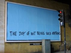 graffiti on the side of a building that says the joy of not being sold anything