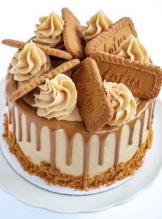 a close up of a cake on a plate with icing and cookies around it