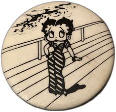 a button with a drawing of a woman wearing a tie on it's side