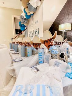 a table set up with blue and white decorations for a baby's first birthday