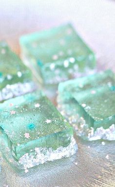 several pieces of green and white soap sitting on top of a silver tray with glitter