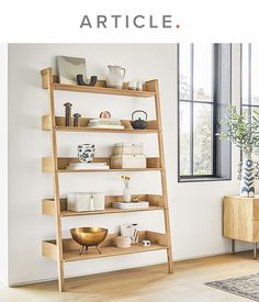 a wooden shelf with various items on it in front of a window, and the words article above it