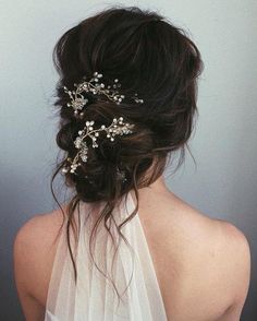 the back of a woman's head wearing a white veil with flowers on it