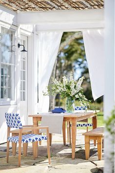 an outdoor dining area with blue and white chairs