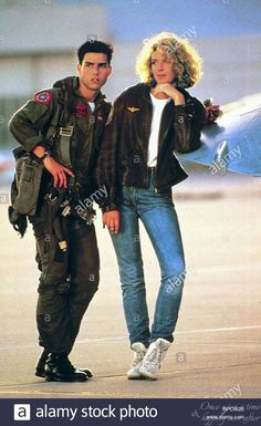 a man and woman standing next to each other in front of an airplane on the tarmac