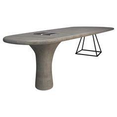 a concrete table with a metal base and an iron frame on the top that is shaped like a surfboard