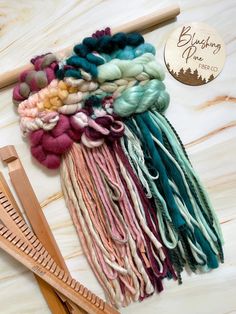 several skeins of yarn next to a pair of scissors and a wooden ruler