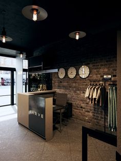 the inside of a clothing store with clocks on the wall