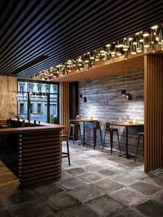 an instagramted photo of a bar and dining area with lights on the ceiling