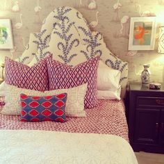 a bedroom with flamingos on the wall behind the headboard and pillows in front of the bed