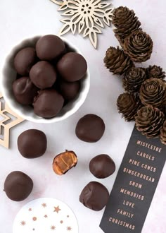 chocolate candies and pine cones are on the table next to a christmas ornament