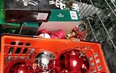 an orange shopping cart filled with christmas ornaments