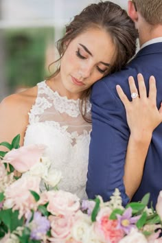 a bride and groom embracing each other with their wedding rings on their shoulders, surrounded by flowers