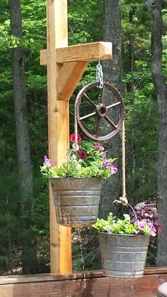 two metal buckets with flowers hanging from them