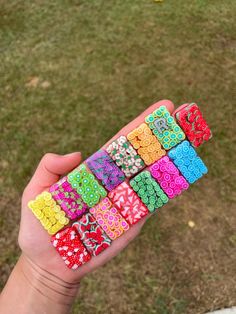 a hand holding a bunch of different colored bracelets