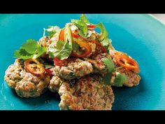 some meat patties are on a blue plate with cilantro and red peppers