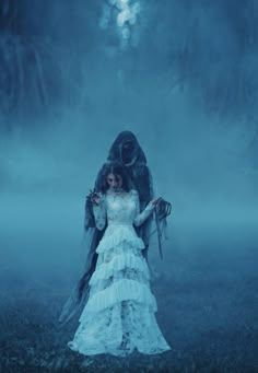 a woman in a white dress is standing in the fog