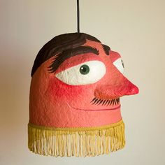 a red and black mask hanging from a ceiling