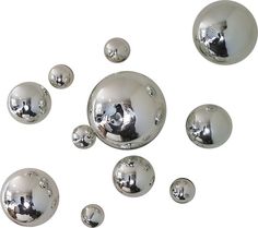 many shiny silver balls floating in the air with one cat on it's head