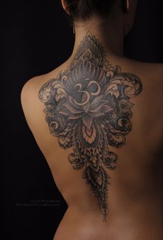 the back of a woman's body with tattoos on it