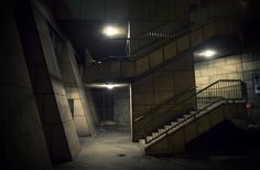 an empty stairwell with stairs and lights at night