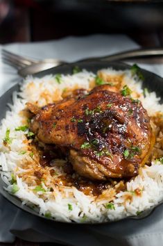 a plate topped with rice and meat covered in sauce