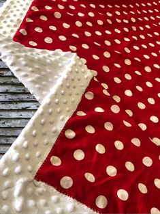 a red and white polka dot quilt on top of a table