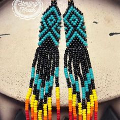 Slip on these Aztec seed bead earrings and treat yourself to the snug and stylish embrace of eye-catching colors! These 4.5 pieces are like a tiny multicolor fiesta for your ears - only much cooler. Let the bright shades of these danglers do the talking and show the world that you are one trend-savvy fashionista! Beaded Earrings Native, Metalsmithing Jewelry, Sterling Jewelry, Beading Projects, Earring Patterns, Seed Bead Earrings, Brick Stitch, Fringe Earrings, Loom Beading