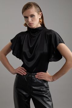 Elevate Your Top Selection With Our Satin Blouse, With A Relaxed Fit, And A Statement Draped Neckline. This Piece Pairs Well With Anything, From A Flowing Maxi Skirt, To Tailored Trousers, To Jeans For An Elevated Look That Will Take You Seamlessly From Day To Night. Viscose Satin High Neck Woven Blouse High Quality Satin Fabric Statement Draped Design Relaxed Silhouette Sleek, Minimal Design High Neckline Button Fastening Behind Neck Petite Work Outfits, Petite Wedding Guest Dresses, Dress Leather Boots, Tall Skirt, Plus Size Workwear, Draped Neckline, Outfits Petite, Petite Coat, Designer Drapes