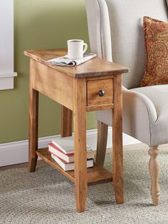 a small wooden table with a coffee cup on top of it next to a chair