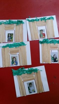 four pictures hanging on a red wall with green ribbon around them and the frames are made out of wood