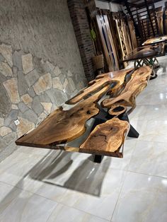 a wooden table sitting on top of a white tile floor next to a stone wall