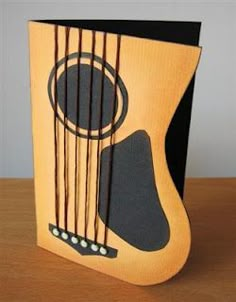 a card with an acoustic guitar on it's front and back sides, sitting on a table