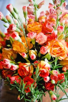 a vase filled with lots of different colored flowers