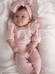 Watch your little girl blossom and bloom in our Daisy Jumpsuit. In our new color, Autumn Rose, this pretty in pink ensemble is a beautiful dusty rose, perfect for your little flower bud. This jumpsuit is decorated with three embroidered daisies on the front for extra cute character, and ruffle details on the sleeves that will look like little petals on your little one's shoulders. The look is completed with a matching headband tied on top with a bow. Designed for ease of dressing, it features co Newborn Girl Winter Outfits, Daisy Jumpsuit, Pink Baby Clothes, Embroidered Daisies, Ella Bella, French Baby, Diaper Bag Accessories, Autumn Rose, Baby Basics