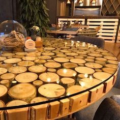 a table with many candles on it in a room filled with furniture and decor items