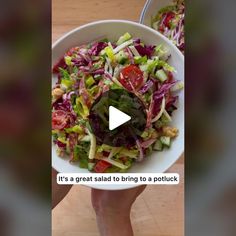 a person holding a bowl of salad with lettuce and tomatoes