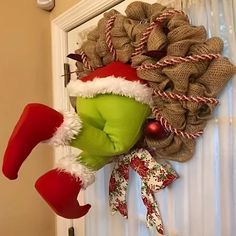 a wreath is hanging on the front door with christmas stockings and santa's hats