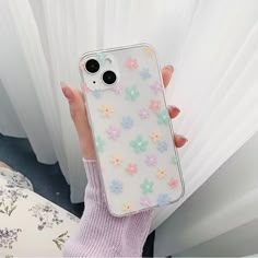 a person holding up a phone case with flowers on it