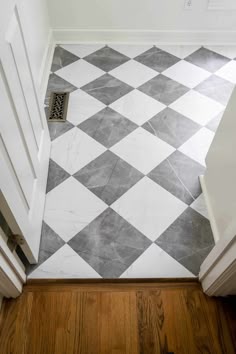 a white and grey checkered floor in a hallway with wooden floors, an open door and a vent on the wall