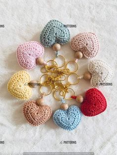 the crocheted heart keychains are arranged in different colors and sizes, along with wooden beads