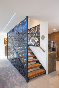 a stair case in the middle of a room with wooden steps and metal railings