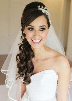 a woman in a wedding dress with a veil on her head and a tiara