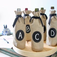 three wine bottles in burlocks with the letters abc and d on them