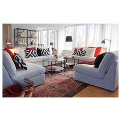 a living room with couches, chairs and rugs in front of large windows