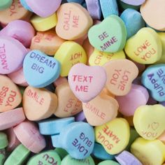 heart shaped conversation cookies on a doily with words written in different colors and shapes