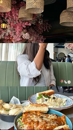 there is a woman sitting at a table with many plates of food in front of her