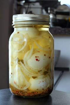 a jar filled with pickled onions sitting on top of a counter